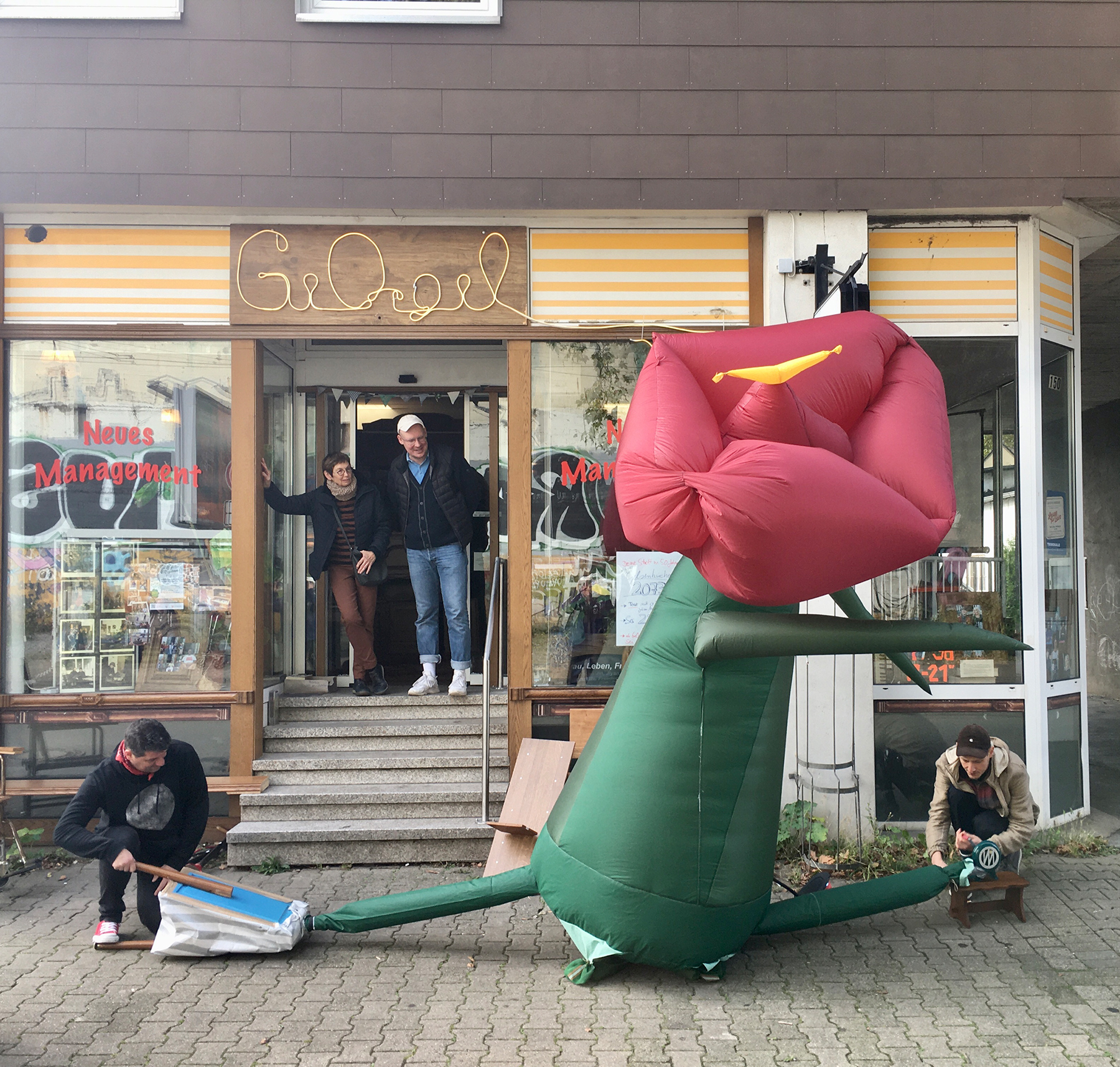 Eine aufblasbare Skulptur einer Blume wird vor dem GeOrgel mit einem Blasebalg aufgeblasen.