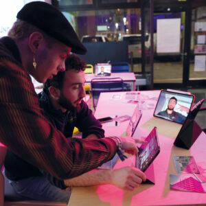 Zwei Personen Arbeiten auf Ipads, welche das Gesicht der einen Person zeigen.