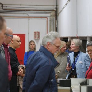 Auf dem Bild stehen ganz viele Menschen in einem Raum.